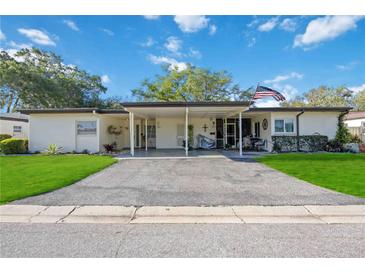 Property exterior with carport and nicely landscaped lawn at 3530 Tree Line Dr # 4, Sarasota, FL 34231