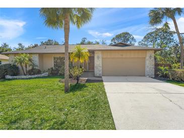 Tan house with a two-car garage and palm trees in the front yard at 4410 Little John Trl, Sarasota, FL 34232