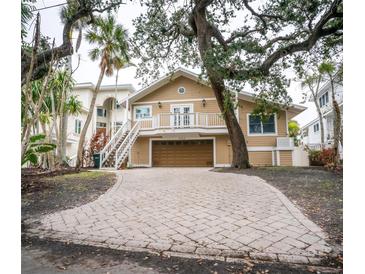 Tan two-story house with a large driveway and mature landscaping at 5169 Oxford Dr, Sarasota, FL 34242