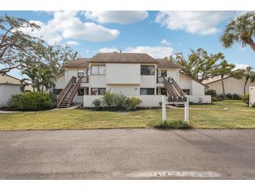 Front view of a two-story condo building with stairs and landscaping at 712 Bird Bay Dr # 146, Venice, FL 34285