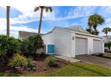 White house with two-car garage, landscaped yard, and blue gate at 941 Waterside Ln, Bradenton, FL 34209