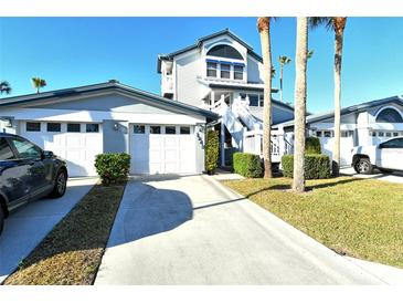 Exterior view of a charming two-story home with attached garage and lush landscaping at 1243 Siesta Bayside Dr # D, Sarasota, FL 34242