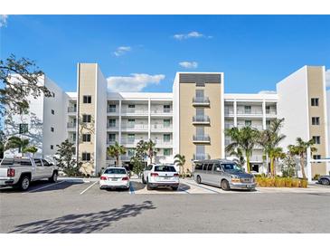 Modern building exterior with ample parking and tropical landscaping at 1703 N Tamiami Trl # 209, Sarasota, FL 34234