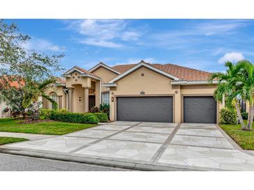 Beautiful two-story home with a three-car garage and manicured lawn at 4917 Sabal Lake Cir, Sarasota, FL 34238