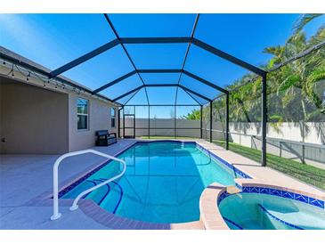 Relaxing screened pool and spa with patio and lush landscaping at 11306 77Th E St, Parrish, FL 34219