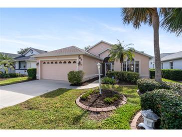Well-maintained house with a two-car garage and attractive landscaping at 204 Venice Palms Blvd, Venice, FL 34292