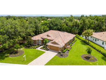Single-story home with tile roof, driveway and landscaped lawn at 3861 Royal Hammock Blvd, Sarasota, FL 34240