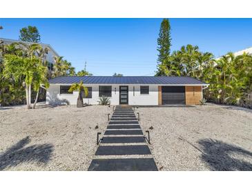 Modern home with a metal roof, walkway, and landscaped yard at 431 Avenida De Mayo, Sarasota, FL 34242