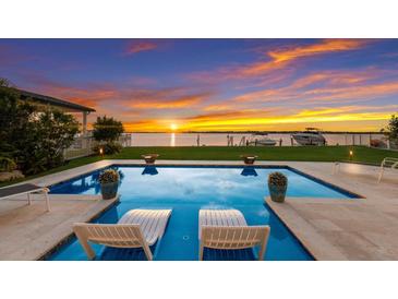 Stunning pool with sunset view, inviting lounge chairs, and spacious patio at 696 Regatta Way, Bradenton, FL 34208