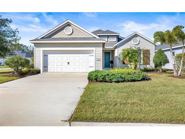 Single-story home with white garage door and landscaped lawn at 7521 Ridgelake Cir, Bradenton, FL 34203