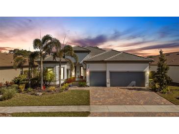 Attractive single-story home with gray roof, two-car garage, and landscaped yard at 12366 Marsh Pointe Rd, Sarasota, FL 34238