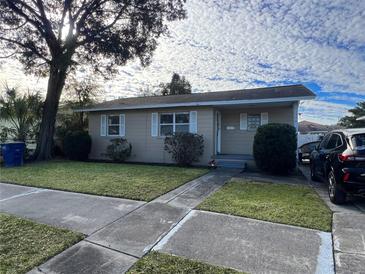 Tan house with a spacious yard and a long driveway at 1308 W Cypress St, Tampa, FL 33606