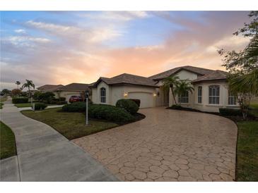 One-story home with a tile roof, and a large driveway at 2763 Phoenix Palm Ter, North Port, FL 34288