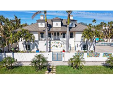 Two-story home with metal roof, gated entry, and artistic wall decor at 345 Madison Dr, Sarasota, FL 34236