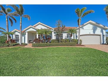 Beautiful two-story home with a manicured lawn and palm trees at 366 S Creek Ct, Osprey, FL 34229