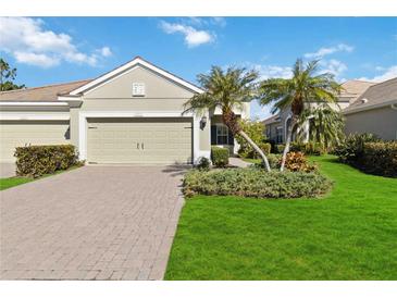 Single-story house with two-car garage, landscaping, and paved driveway at 4891 Maymont Park Cir, Bradenton, FL 34203