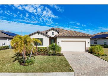 Single-story home with tile roof, two-car garage, and lush landscaping at 6534 Clairborne Ln, Lakewood Ranch, FL 34211