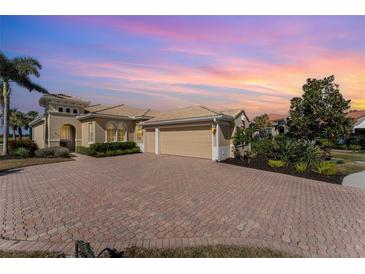 Beautiful home with a brick driveway and a three-car garage at sunset at 108 Savona Ct, North Venice, FL 34275