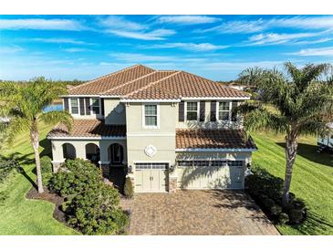 Two-story house with tile roof, large driveway, and landscaping at 16625 5Th E Ave, Bradenton, FL 34212