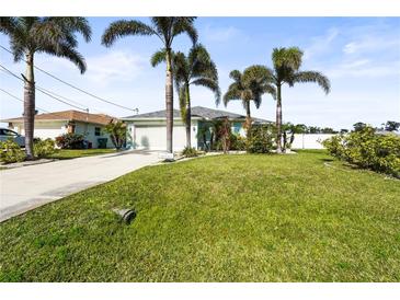 Single-story home with a green lawn and palm trees at 170 Bonita Dr, Rotonda West, FL 33947