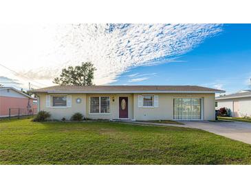 Ranch-style home with a well-manicured lawn and a carport at 1778 Palm Dr, Venice, FL 34293