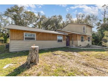 Tan two-story house with a spacious yard at 288 Ambler St, Port Charlotte, FL 33954