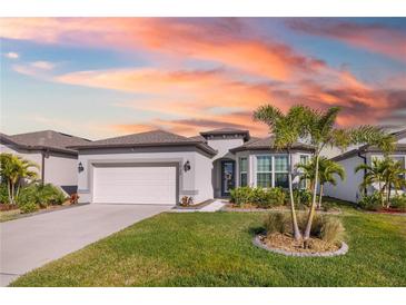 White one-story house with a two-car garage and palm trees in front at 2930 61St E Dr, Ellenton, FL 34222