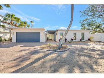 Charming single-story home with a well-manicured brick driveway and simple landscaping, accented by a palm tree at 320 Avenida Leona, Sarasota, FL 34242