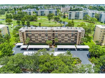 Aerial view of a condo building with parking and a golf course nearby at 3620 Ironwood Cir # 405, Bradenton, FL 34209