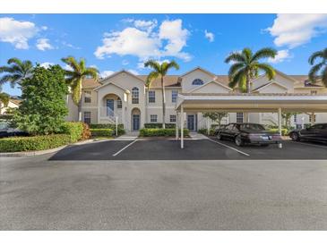 Two-story condo building with covered parking and lush landscaping at 4250 Players Pl # 2622, Sarasota, FL 34238