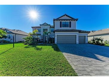 Two-story house with gray siding, tile roof, and a paved driveway at 4852 Coastal Days Ln, Bradenton, FL 34211