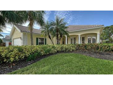 Single-story home with tile roof, lush landscaping, and a two-car garage at 5781 Girona Pl, Sarasota, FL 34238