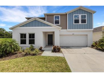 Two-story house with gray and blue siding, white trim, and a two-car garage at 12977 Twin Bridges Dr, Riverview, FL 33579