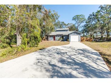 Newly painted house with a long driveway and mature trees at 2037 Linwood Way, Sarasota, FL 34232