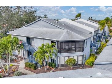 Two-story condo building with screened balconies, lush landscaping, and stairs at 2728 71St Street W Ct # 2078, Bradenton, FL 34209