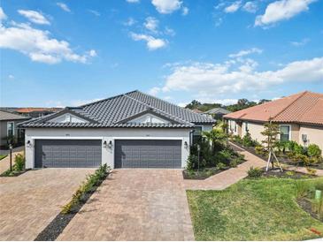 Two-car garage, paver driveway, landscaped walkway, and attractive exterior at 3016 Formia Ct, Bradenton, FL 34211