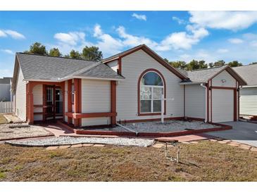 Single-story house with a landscaped lawn, red-trimmed exterior, and a two-car garage at 3815 42Nd W Ave, Bradenton, FL 34205