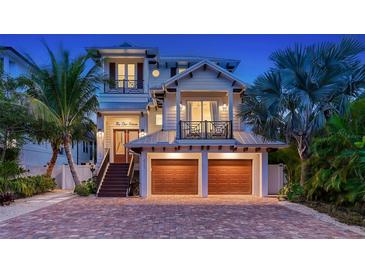 Stunning two-story home with a metal roof, two-car garage, and brick driveway at 421 Pine Ave, Anna Maria, FL 34216