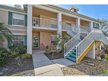 Charming condo with white railings, stairs and nicely landscaped garden beds in a well-maintained community at 4705 Sand Trap Street E Cir # 105, Bradenton, FL 34203