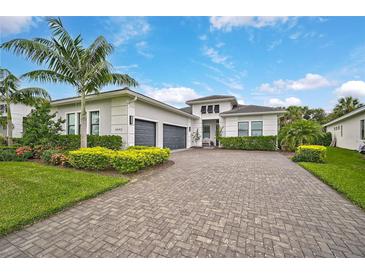 Two-story house with gray garage doors and a brick driveway at 4940 Surfside Cir, Bradenton, FL 34211