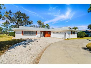 Ranch-style home with a circular driveway and mature landscaping at 617 Whitfield Ave, Sarasota, FL 34243