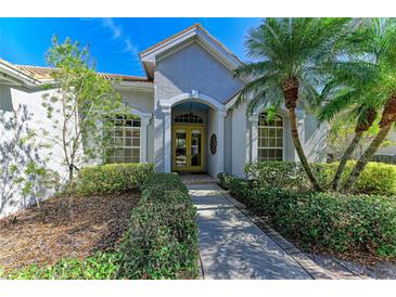 Attractive single-story home with a well-manicured lawn and lush landscaping at 7215 Treymore Ct, Sarasota, FL 34243