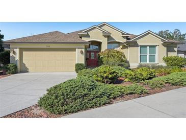 House exterior featuring a two-car garage and well-manicured landscaping at 7302 Deer Crossing Ct, Sarasota, FL 34240