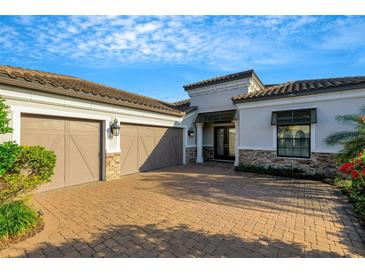 Two-car garage with paver driveway and attractive exterior at 5341 Greenbrook Dr, Sarasota, FL 34238