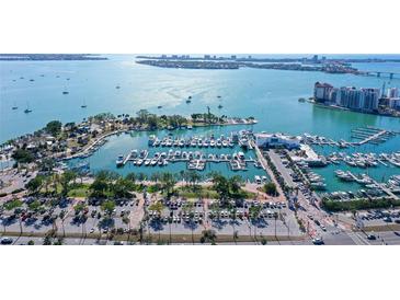 Expansive aerial view of a marina showcasing numerous boats and yachts with waterfront condo buildings in the background at 1350 Main St # 1410, Sarasota, FL 34236