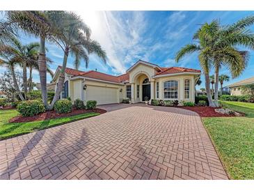 Beautiful home with tile roof, palm trees, and a brick driveway at 149 Montelluna Dr, North Venice, FL 34275