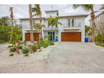 Two-story home with double garage doors and landscaped front yard at 238 Oak Ave, Anna Maria, FL 34216