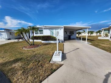 Single-wide mobile home with carport and landscaped yard at 308 Danube Cir, Bradenton, FL 34207