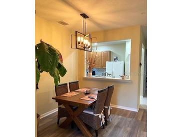 Bright dining area with wood table and chairs, view of kitchen at 3453 Parkridge Cir # 18-101, Sarasota, FL 34243