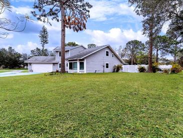 Two-story home with a lush lawn, attached garage and white fence surrounding the property at 3822 Ironwood Ct, Sarasota, FL 34243